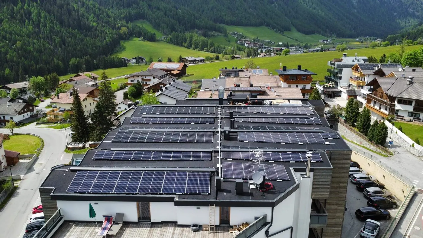 Drohnenaufnahme eines großen Flachdachs mit ballastierten PV-Modulreihen in Tirol